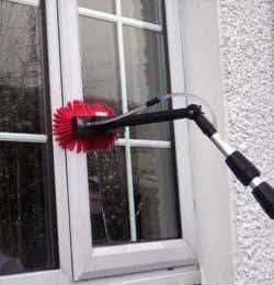 Albert cleaning a window with a water-fed pole and soft brush